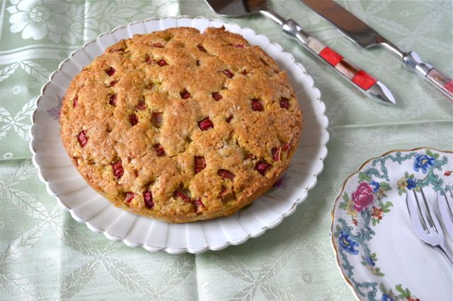 Remarkable Rhubarb Cake sitting on a plate with forks and cutters at the ready.