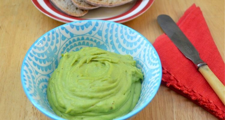A blue bowl of green minted broad bean spread.