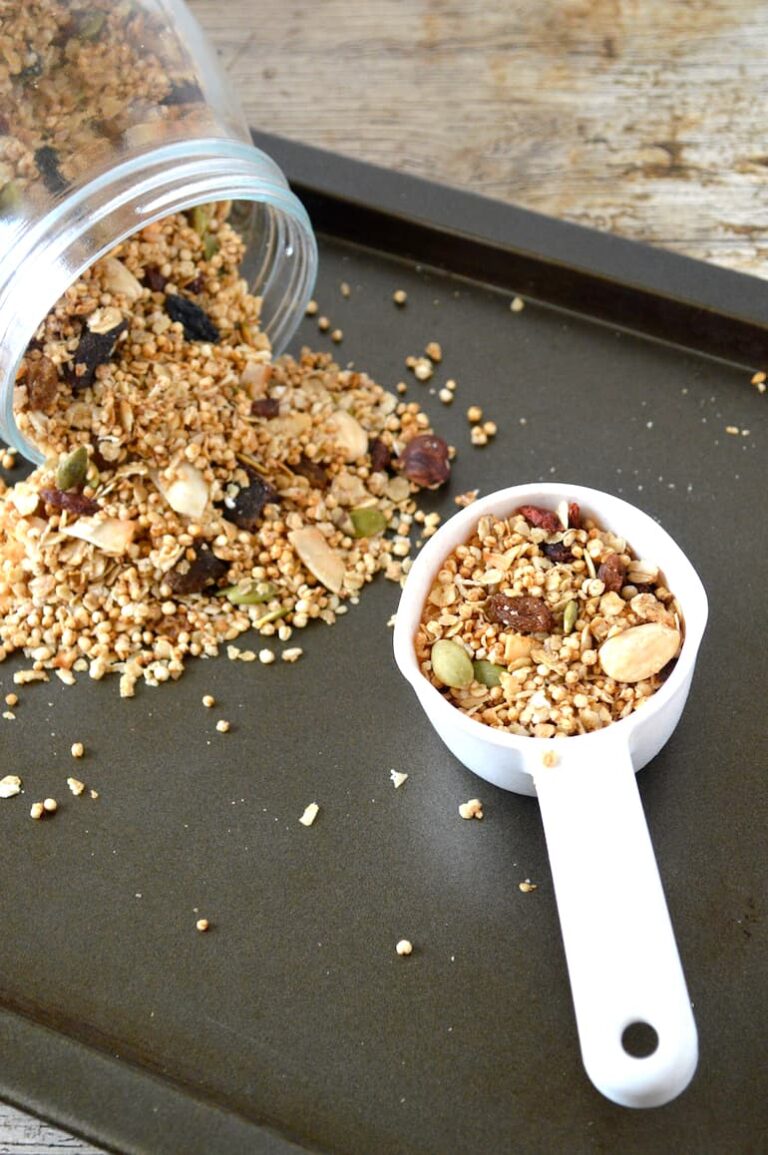 Scoop of gorgeous gluten-free granola with some spilling out of jar.