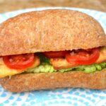 Tofu lettuce tomato sandwich on blue plate.