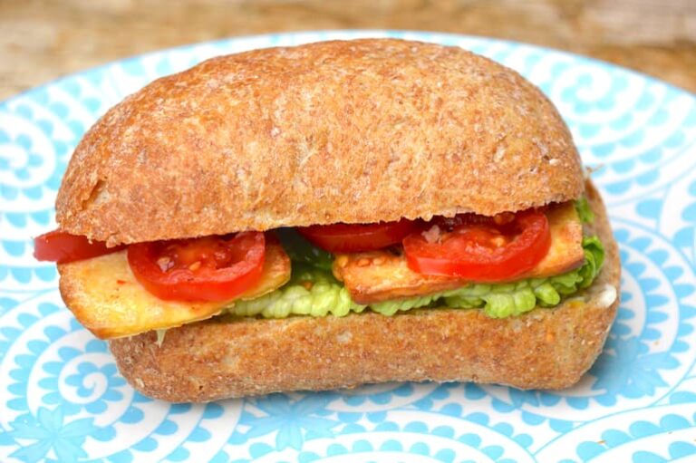 Tofu lettuce tomato sandwich on blue plate.