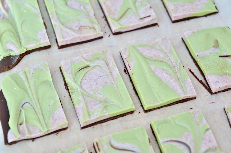 Squares of homemade matcha and cranberry festive chocolate candies.