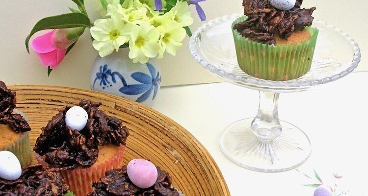Easter Nest Cupcakes with a plate of mini eggs and a vase of primroses.