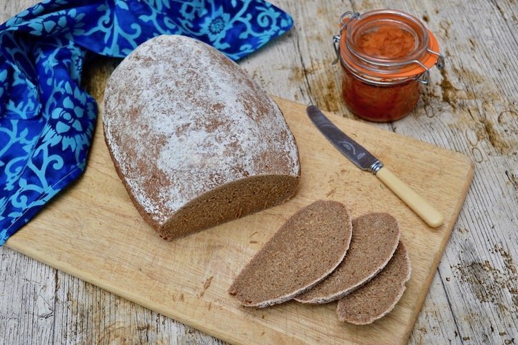Loaf of Latvian Rye Sourdough sliced with a jar of carrot jam.