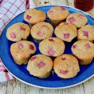 Twelve spelt rhubarb mini muffins sitting on a blue plate.