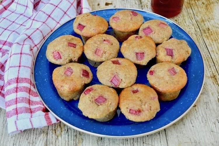 Twelve spelt rhubarb mini muffins sitting on a blue plate.