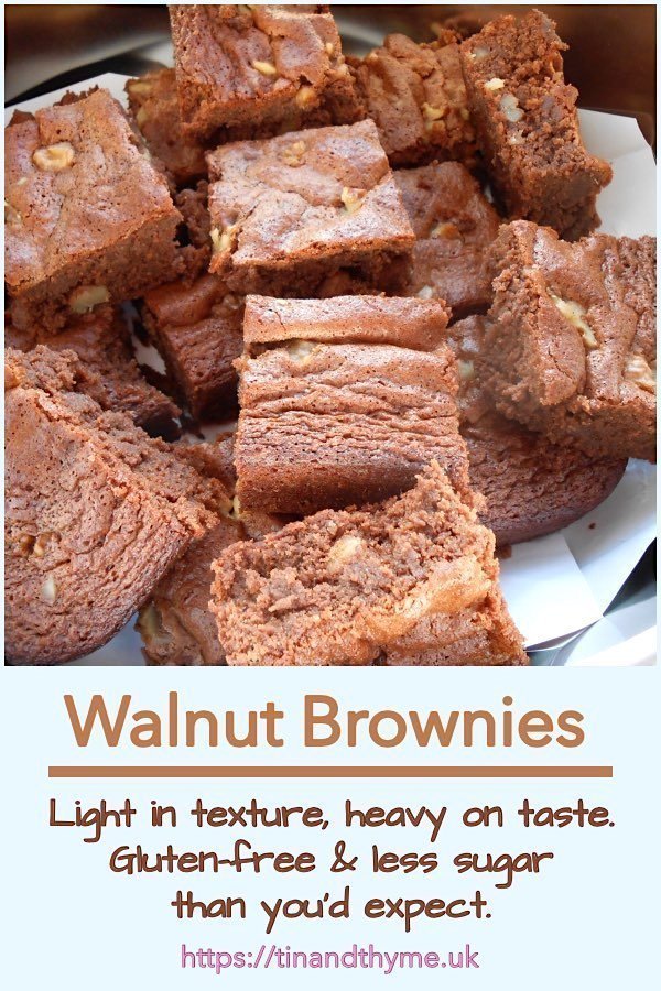 Pile of walnut brownies on a tray.