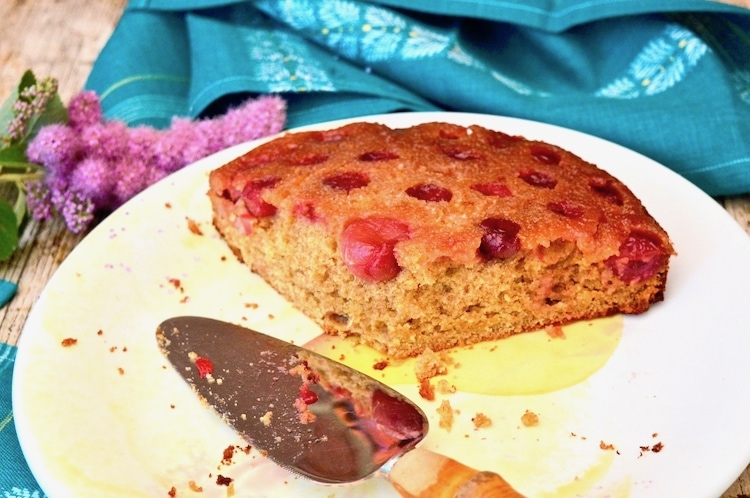 Slice of honey gooseberry upside-down cake on a plate with cake slice.