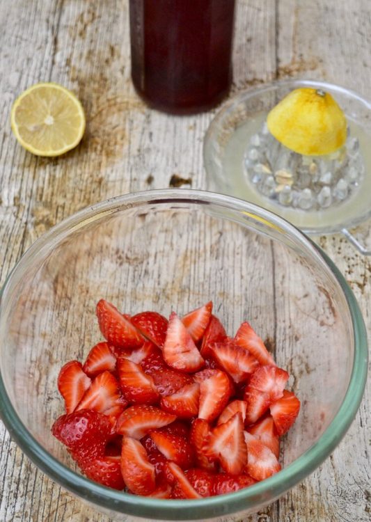 Strawberries macerating in rose syrup and lemon.