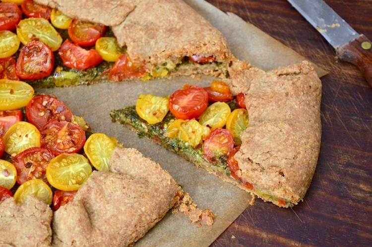 Slice of rustic tomato galette with homemade basil pesto.