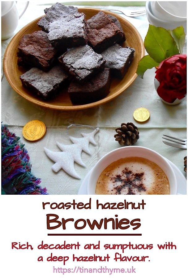 Plate of roasted hazelnut brownies with a cup of coffee, a rose and Christmas decorations.
