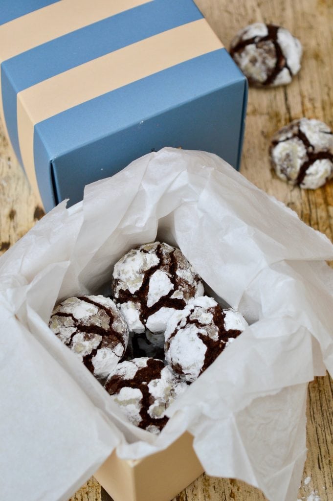 Chocolate crinkle cookies with roasted hazelnuts being boxed up for Christmas gifts.