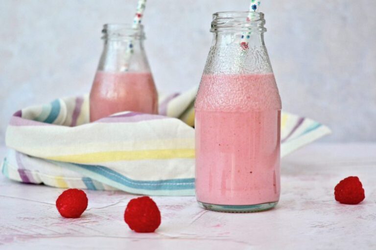 Raspberry cashew nut milk smoothie in bottles with straws.