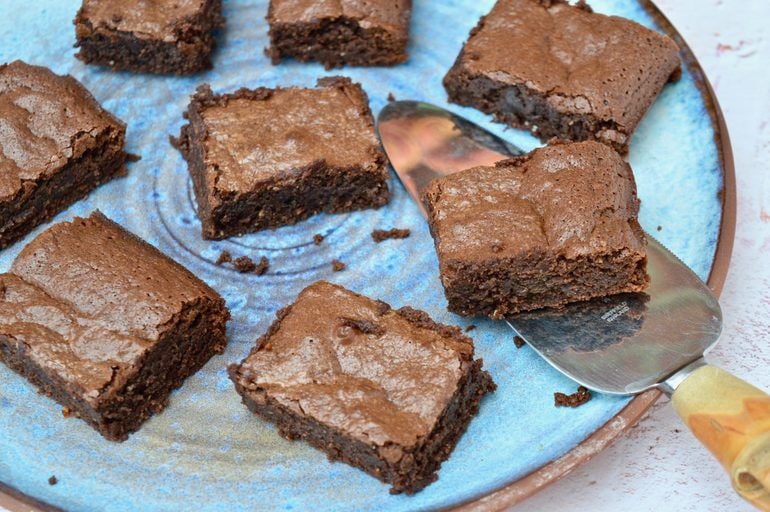 Spicy orange brownies on a blue plate and one on a cake slice.