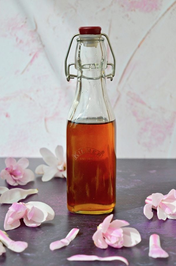 Bottle of Magnolia Syrup with magnolia blossoms.