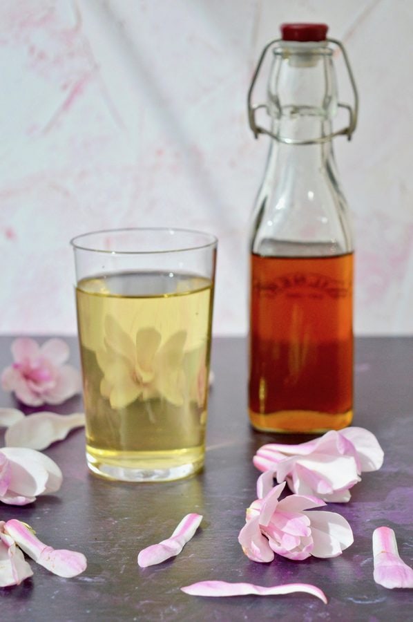 Bottle of Magnolia Syrup with a glass of cordial and water.