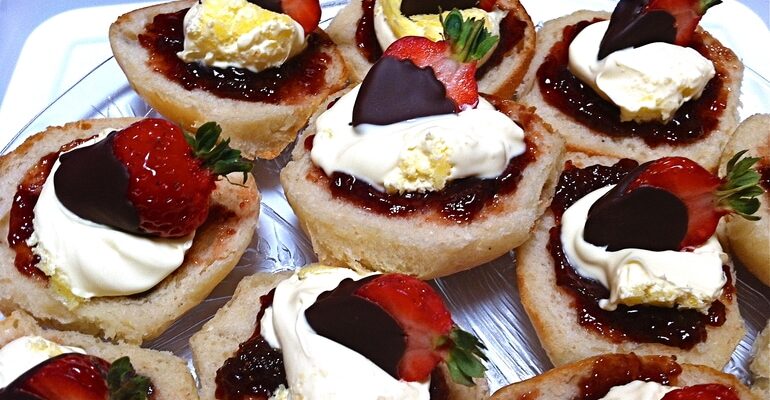 Cornish splits topped with strawberry jam, clotted cream and chocolate dipped strawberries.