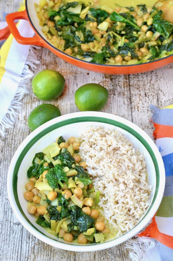 Bowl of spinach coconut curry with rice. Napkins and limes in the background.