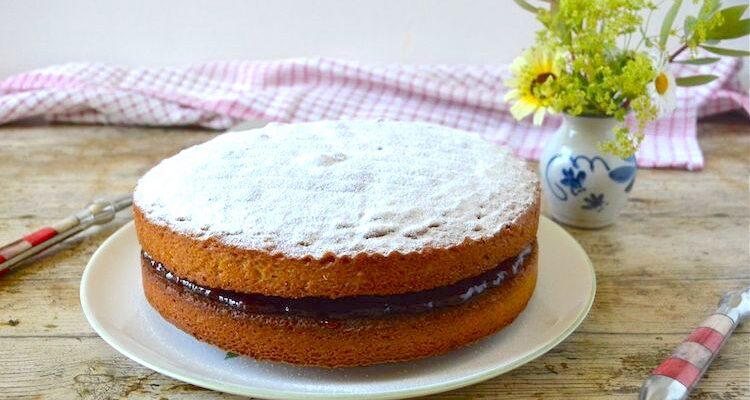 A wholemeal Victoria sandwich sponge cake on a plate.