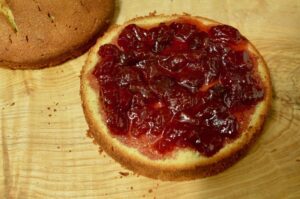 Sponge bottom covered in strawberry jam.