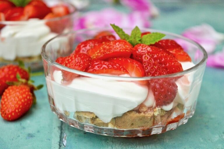 A bowl of strawberries and cream summer dessert.