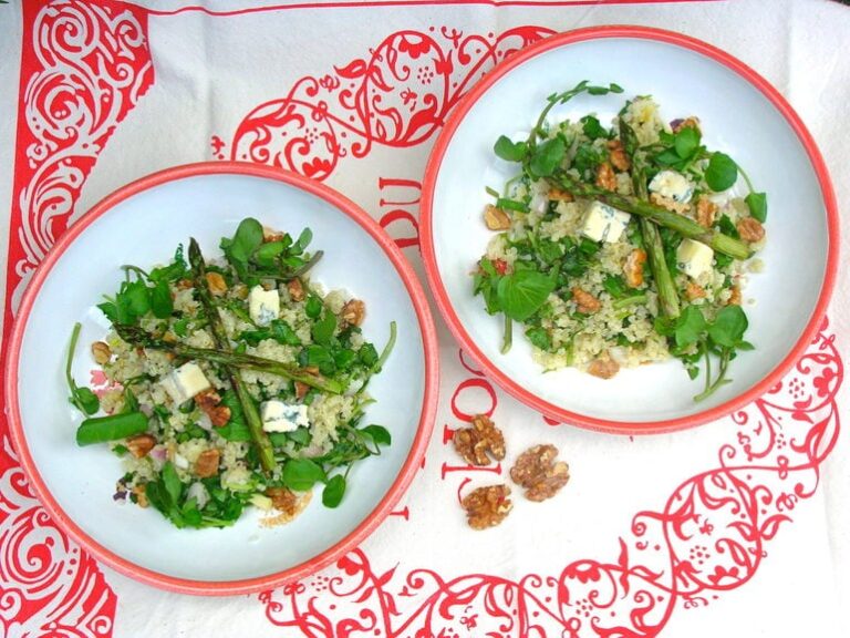 Two bowls of quinoa salad with watercress, walnuts, blue cheese and roasted asparagus.