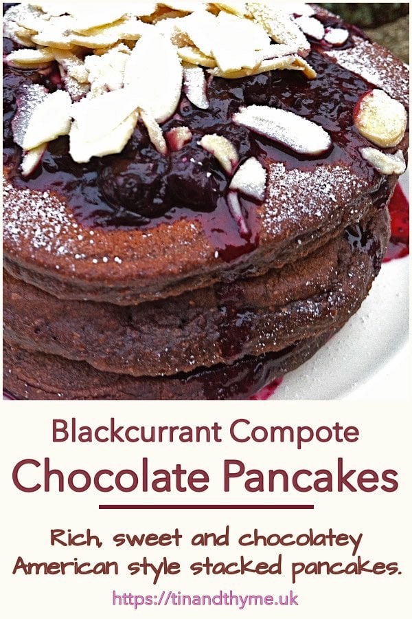A stack of chocolate pancakes covered with blackcurrant compote and flaked almonds.