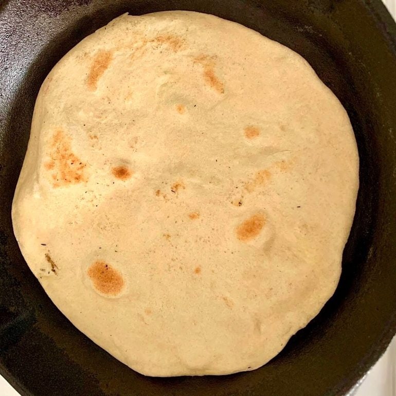 Flatbread cooking in a pan.