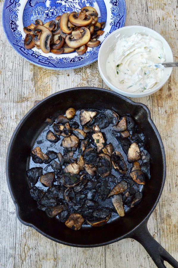 Two types of cooked mushrooms and a bowl of herby cream cheese.