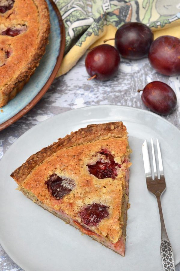 A slice of Plum Almond Tart with plums.