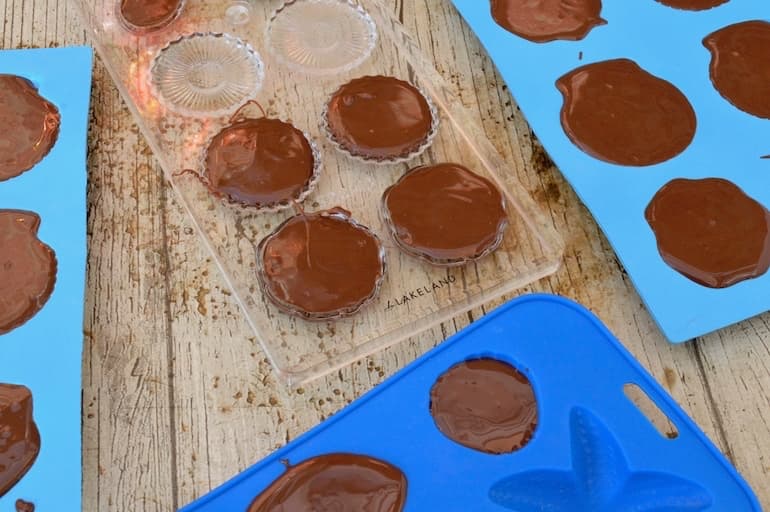 Filling moulds with melted chocolate.