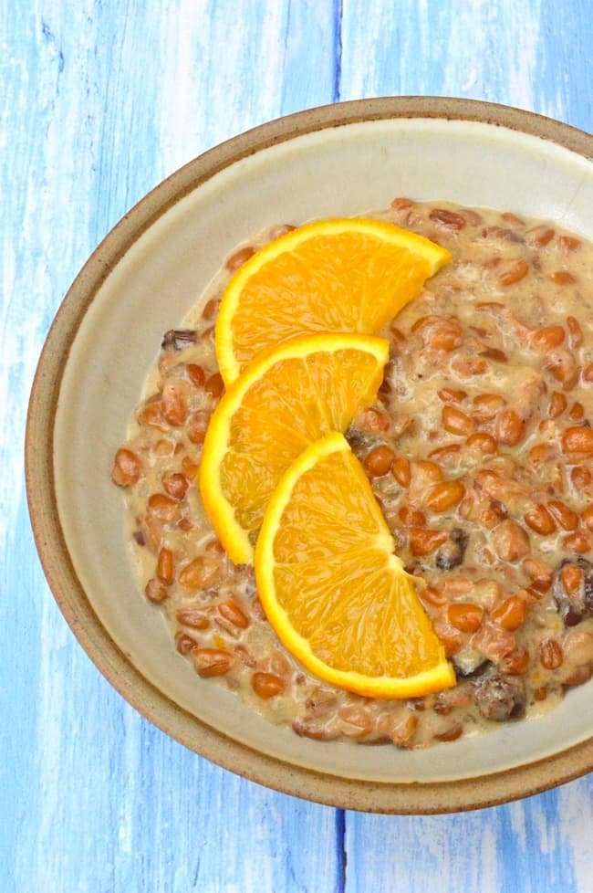 A bowl of frumenty (wholegrain wheat porridge) with orange slices.