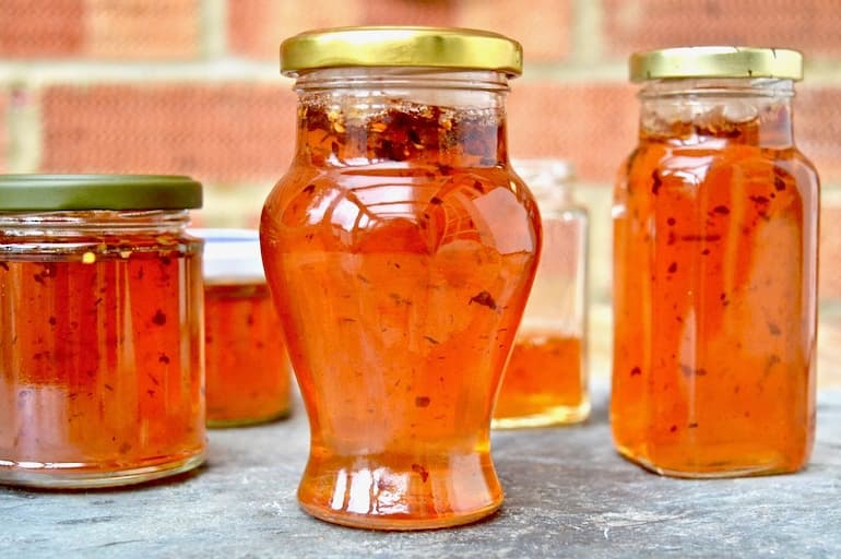 Jars of quince jelly with apples and chilli flakes.