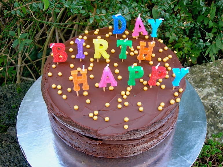 Chocolate Treacle Cake with icing and Happy Birthday candles on the top.