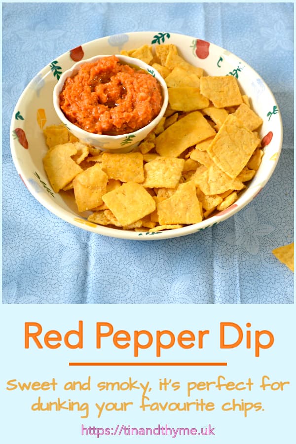 Smoky red pepper dip sitting in a bowl of chips.