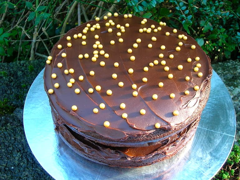 Chocolate Treacle Cake with icing and golden decorations on the top.
