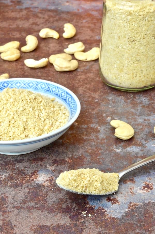 Vegan Parmesan Cheese, on a spoon, in a bowl and in a jar.