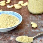 Homemade vegan Parmesan Cheese, on a spoon, in a bowl and in a jar.