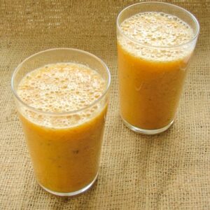 Two glasses of Tropical Smoothie with Coconut, Mango and Banana.