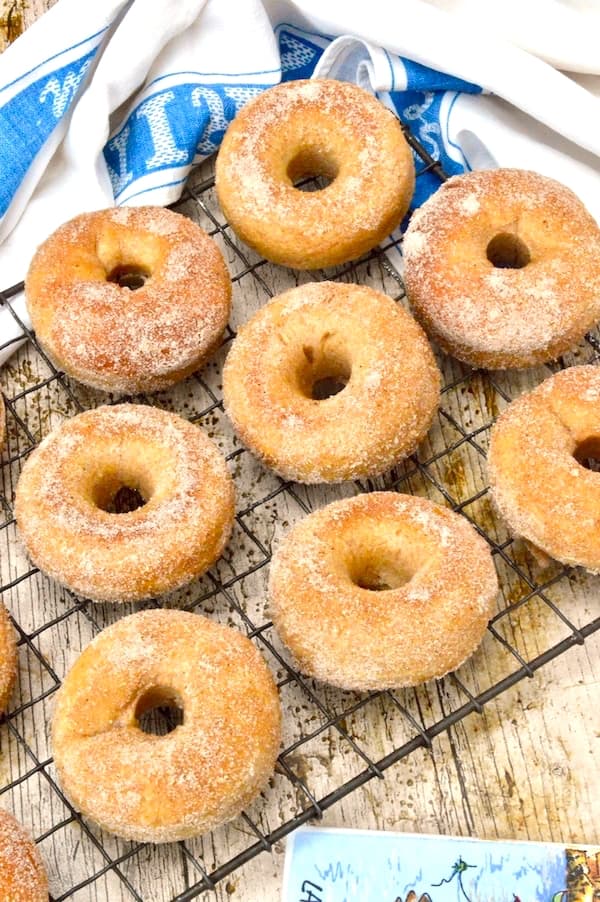Sugared baked yeast doughnuts on a cooling rack.