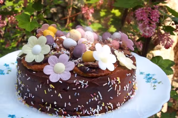 An Easter chocolate orange cake decorated with edible daisies via Lavender and Lovage.