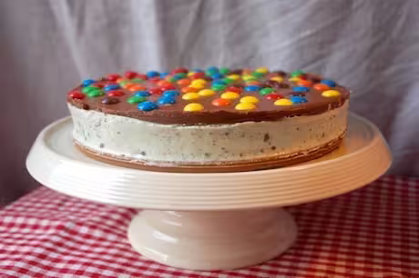 M&M's cheesecake on cake stand.