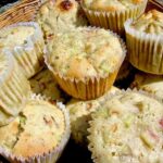 A pile of rhubarb and white chocolate muffins in a basket.