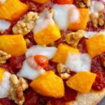 Squash pizza with walnuts and goat's cheese on a chocolate tomato sauce.