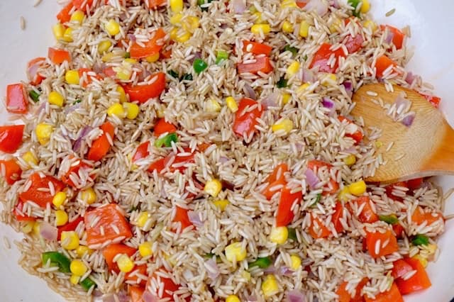 Rice frying with other vegetables in a pan.
