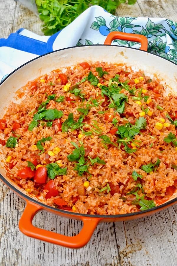 A pan of Mexican brown rice with coriander scattered over the top.