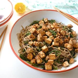 A large bowl of samphire noodles with miso marinated tofu and chopsticks.