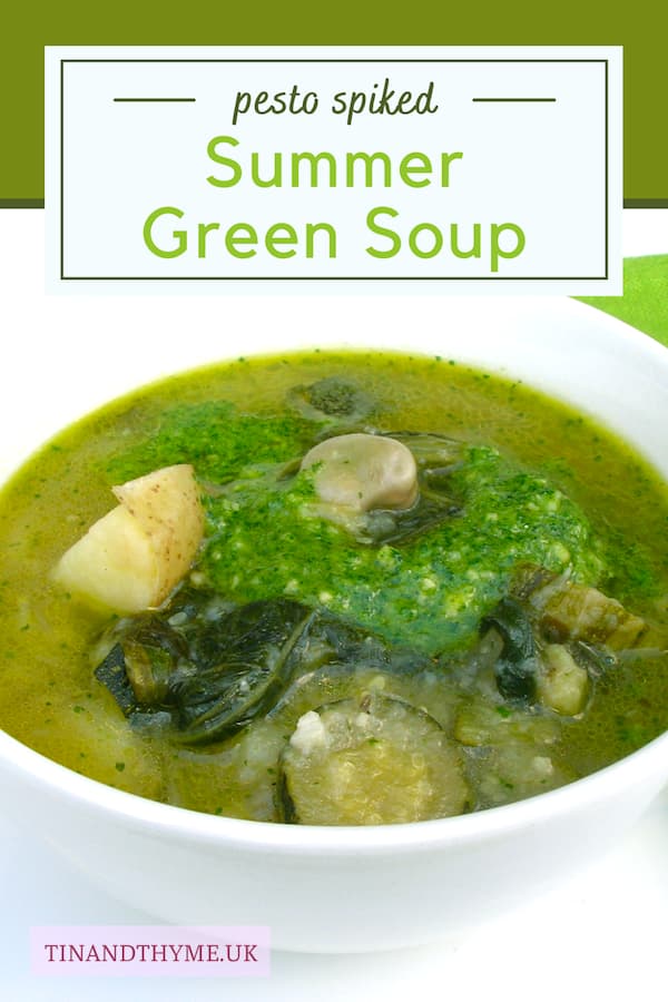 A bowl of chunky green summer soup with parsley and almond pesto.