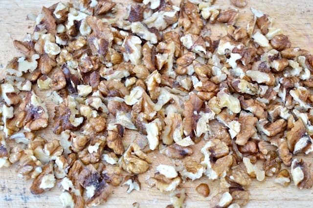 Roughly chopped walnuts on a board.