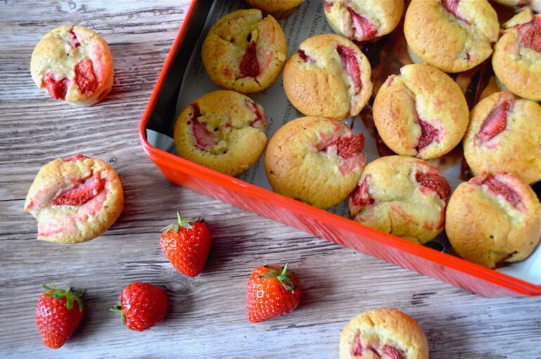 A tin of little strawberry cream cakes with real strawberries.